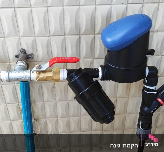 מערכת השקיה עם ברזים וצינורות על קיר